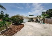 Single-story home with a well-maintained front yard, driveway, and attached garage on a sunny day at 1615 Stonehaven Way, Tarpon Springs, FL 34689