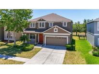Charming two-story home with a well-maintained lawn, inviting front porch and a two car garage at 30526 Annadale Dr, Wesley Chapel, FL 33545