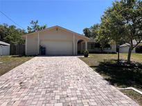 Charming home featuring a brick driveway, a spacious two-car garage and low maintenance landscaping at 4363 Elwood Rd, Spring Hill, FL 34609