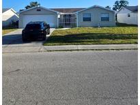 Charming single-story home featuring an attached garage and well-maintained front yard at 6241 Westport Dr, Port Richey, FL 34668