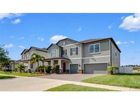 Beautiful two-story home with well-manicured lawn, brick driveway, and two-car garage at 11720 Navajo Sandstone St, Riverview, FL 33579