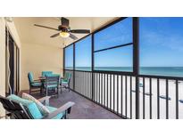 Enjoy breathtaking ocean views from the condo's spacious, screened-in balcony with dining set and comfortable chairs at 13720 Gulf Blvd # 305, Madeira Beach, FL 33708