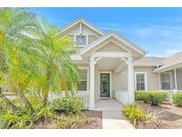 Charming single-story home features a covered front porch with lovely landscaping and a welcoming green front door at 215 Oceania Ct, Apollo Beach, FL 33572