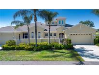 Charming single-story home with a well-manicured lawn, tropical palm trees, and a two-car garage at 2246 Sifield Greens Way # 36, Sun City Center, FL 33573