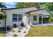 Charming home features a well-manicured lawn, complemented by decorative rock accents and lush landscaping at 2873 Karen Ave, Largo, FL 33774