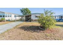 Charming single-story home featuring a covered parking area and a cozy screened-in porch at 37229 Cora Ave, Zephyrhills, FL 33542