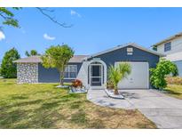 Charming one-story home featuring a stone accent wall, manicured lawn, and an attached single-car garage at 4124 Pine Dale Ct, Hernando Beach, FL 34607