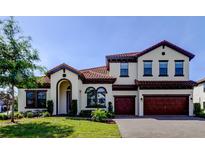 Stunning two-story home with red tile roof, arched entry, and a three-car garage at 4975 Night Star Trl, Odessa, FL 33556