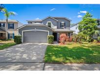 Charming two-story home featuring a well-maintained lawn and a two-car garage at 6607 Gates Pointe Way, Riverview, FL 33578