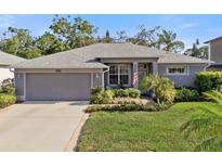 Charming single-story home boasts a well-manicured lawn and beautiful landscaping, creating a welcoming curb appeal at 708 Sandy Hills Ave, Tarpon Springs, FL 34689