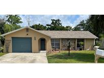 Charming single-story home with a stone accent wall, well-maintained lawn, and attached garage at 8317 Needles Dr, Hudson, FL 34667