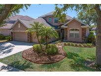 Charming two-story home with well-manicured lawn and inviting curb appeal, set under a clear blue sky at 10141 Deercliff Dr, Tampa, FL 33647
