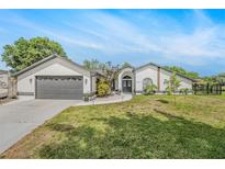 Charming single-story home featuring a well-manicured lawn and a two-car garage at 12317 Smokey Dr, Hudson, FL 34669