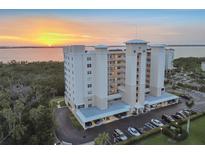 Stunning aerial view of condo building near the water at sunset with beautiful landscaping and covered parking at 2625 Terra Ceia Bay Blvd # 406, Palmetto, FL 34221