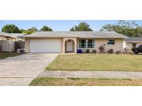 Charming single-story home with a well-maintained lawn, arched doorway, and a two-car garage at 2964 Catherine Dr, Clearwater, FL 33759