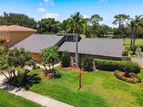 Beautiful home with well-manicured lawn, mature trees, and lush landscaping in a golf community at 3168 Masters Dr, Clearwater, FL 33761