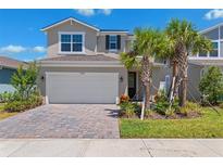Charming two-story home features a two-car garage, brick driveway, and well-maintained landscaping at 31779 Asbury Ave, Wesley Chapel, FL 33545