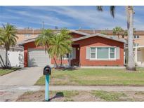 Charming single-story home with red exterior, garage, and a well-maintained front lawn with a mailbox at 3516 Casablanca Ave, St Pete Beach, FL 33706