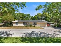 Charming single-story home featuring a metal roof with solar panels and a well-maintained front yard at 38351 7Th Ave, Zephyrhills, FL 33542