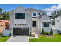 Stunning two-story home with a modern design, elegant landscaping, and a spacious driveway leading to an attached garage at 4607 W Lamb Ave, Tampa, FL 33629