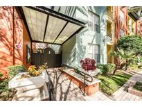 Inviting entryway featuring a covered walkway, lush planters, and handicap access ramp at 504 S Armenia Ave # 1338, Tampa, FL 33609