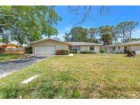 Charming single-story home with a well-maintained lawn and mature trees at 5065 Shore Acres Ne Blvd, St Petersburg, FL 33703