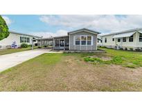Cozy single-story home with a covered parking area and well-maintained front lawn at 5428 Joyce St, Zephyrhills, FL 33542