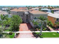 Stunning waterfront home featuring a brick driveway and lush tropical landscaping at 6201 Marbella Blvd, Apollo Beach, FL 33572