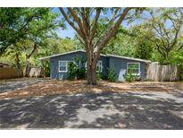 Charming single-story home featuring a blue exterior, mature trees and well kept landscaping at 6225 76Th N Ave, Pinellas Park, FL 33781