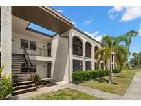 Charming condo building featuring stucco walls, arched balconies, and lush tropical landscaping at 7701 Starkey Rd # 445, Seminole, FL 33777