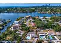 Waterfront property aerial view featuring a private pool, lush landscaping, and stunning bay views with the city skyline on the horizon at 843 37Th Ne Ave, St Petersburg, FL 33704