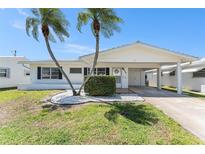 Charming single-story home with a well-maintained lawn and beautiful palm trees in the front yard at 9740 45Th N St, Pinellas Park, FL 33782