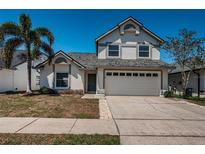 Charming two-story home featuring a two-car garage, manicured lawn, and lush landscaping for enhanced curb appeal at 10906 Kenbrook Dr, Riverview, FL 33578