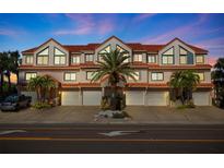 Charming townhome features multiple units, garages, tile roof, palm trees, and inviting curb appeal at 1206 Gulf Blvd # C, Indian Rocks Beach, FL 33785
