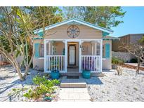 Charming cottage with a front porch, light blue shutters and a quaint compass decoration at 1507 Legion Ln, Indian Rocks Beach, FL 33785
