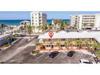 A beachfront condo building with palm trees and parking lot offers easy access to the ocean and resort amenities at 19417 Gulf Blvd # E217, Indian Shores, FL 33785