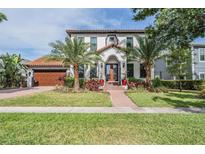 Stunning two-story home with a tile roof, lush landscaping, and a brick walkway leading to the front door at 207 Chippewa Ave, Tampa, FL 33606