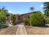 Charming single-story home featuring a neatly landscaped yard and a welcoming entrance under a clear sky at 2700 Pass A Grille Way, St Pete Beach, FL 33706