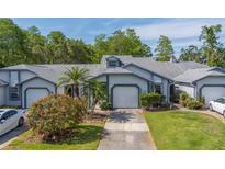 Charming single-story home with a well-manicured lawn, blossoming bushes, and attached one car garage at 39650 Us Highway 19 N # 743, Tarpon Springs, FL 34689