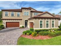 Beautiful two-story home with a well-manicured lawn and a three-car garage with paver driveway at 4024 Woods Rider Loop, Odessa, FL 33556