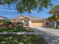 Charming one-story home featuring a manicured lawn, beautiful landscaping, and a spacious two car garage at 6018 Gannetdale Dr, Lithia, FL 33547