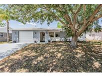 Charming single-story home with stone accents, a front-entry garage, and mature trees at 6333 Aberdeen Ave, New Port Richey, FL 34653