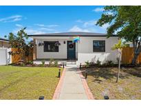 Charming home featuring a well-maintained lawn, inviting walkway, and colorful flower baskets at 6535 3Rd S Ave, St Petersburg, FL 33707
