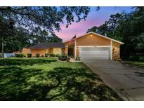 Charming single-story home boasting a manicured lawn and a two-car garage with stone accents at 6938 Coronet Dr, New Port Richey, FL 34655