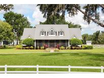 Charming single-Gathering home with a lush green lawn, mature trees, and a metal roof in a peaceful setting at 10101 Bryant Rd, Lithia, FL 33547