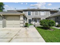 Charming two-story townhome with a one-car garage, landscaped yard, and inviting entryway at 14104 Beauville Ct, Tampa, FL 33624