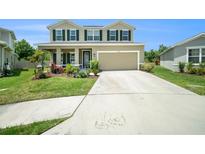 Charming two-story home with well-maintained lawn, two-car garage, and inviting front porch at 18161 Hunters Meadow Walk, Land O Lakes, FL 34638