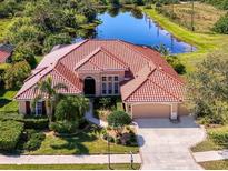 Stunning exterior view of a home with a red tile roof and a serene pond backdrop at 218 Pesaro Dr, North Venice, FL 34275