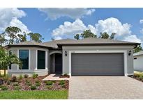 Beautiful single-story home featuring a brick driveway, two-car garage, and well-manicured landscaping at 2528 Charter Oak Dr, North Port, FL 34289