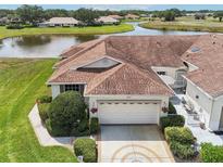 Inviting single-Gathering home featuring a well-manicured lawn, lush greenery, and a decorative driveway at 2602 Novack Ct, Sun City Center, FL 33573